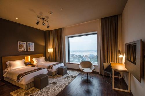 een hotelkamer met 2 bedden en een raam bij Altair - A Boutique Hotel in Calcutta