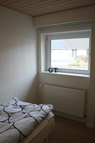 a bedroom with a bed and a window at Havrevang, Luksus ferielejligheder in Lønstrup