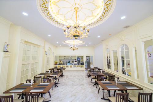 廊开The MACEO Hotel的餐厅设有木桌、椅子和吊灯。