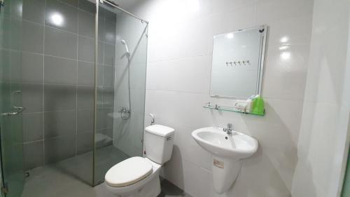 La salle de bains blanche est pourvue de toilettes et d'un lavabo. dans l'établissement Truong Giang Hotel, à Hô-Chi-Minh-Ville