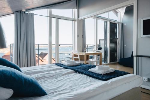 a large bed in a room with large windows at Björholmen Hotell & Restaurang in Björholmen