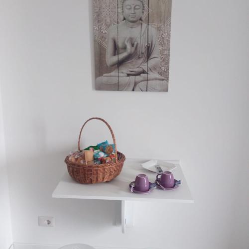 a basket and cups on a shelf with a statue at la staccionata bianca in Viterbo