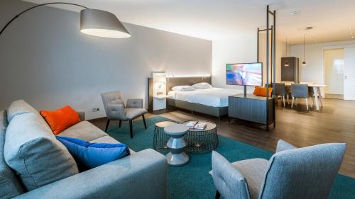 a hotel room with a bed and a living room at Postillion Hotel Dordrecht in Dordrecht