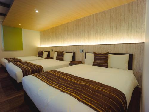 a hotel room with two beds in a room at GRAND BASE Hakata Sumiyoshi in Fukuoka