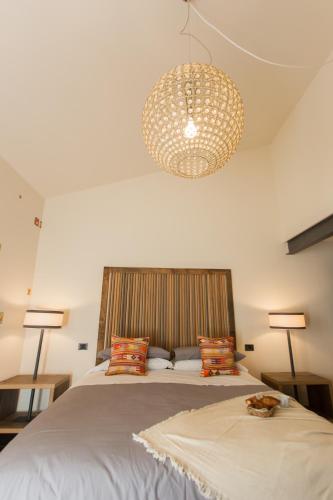 a bedroom with a large bed and a chandelier at Duomo Luxury Apartment Orvieto in Orvieto