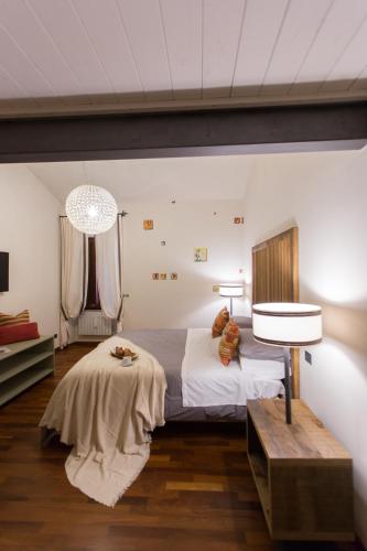 a bedroom with a bed and a table and a lamp at Duomo Luxury Apartment Orvieto in Orvieto