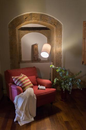 a living room with a red couch and a lamp at Duomo Luxury Apartment Orvieto in Orvieto