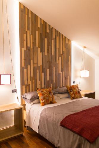 a bedroom with a bed with a large headboard at Duomo Luxury Apartment Orvieto in Orvieto