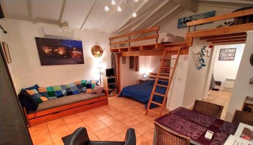 salon z kanapą i łóżkiem piętrowym w obiekcie Gites La Bakénia w mieście Villeneuve-sur-Lot