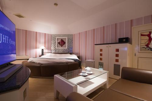 a hotel room with a bed and a living room at HOTEL PERRIER (Adult Only) in Tokyo