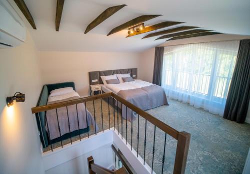 a hotel room with a bed and a balcony with a balcony at Vila JŪRALUX in Palanga