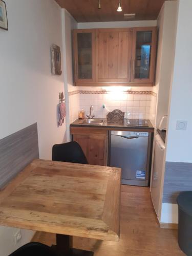 une petite cuisine avec une table en bois et un évier dans l'établissement Le Carlton, à Chamonix-Mont-Blanc