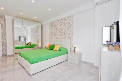 - une chambre blanche avec un lit vert et un miroir dans l'établissement Maison Roberta San Peter, à Rome