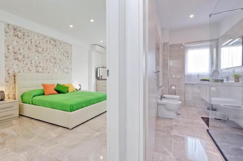 - une chambre avec un lit vert et une salle de bains dans l'établissement Maison Roberta San Peter, à Rome