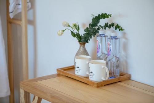 a table with a shelf with a vase and cups on it at 丽江慕云堂观景客栈Lijiang Muyuntang View Hotel in Lijiang