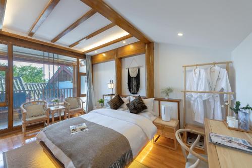 a bedroom with a large bed and a desk at 丽江慕云堂观景客栈Lijiang Muyuntang View Hotel in Lijiang