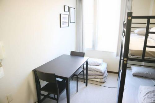 a room with a table and a bunk bed at Joinus Ise Apartment in Ise