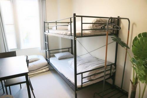two bunk beds in a room with a table at Joinus Ise Apartment in Ise