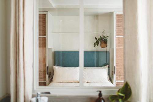 a glass cabinet with a bed with a plant in it at HOY Paris - Yoga Hotel in Paris