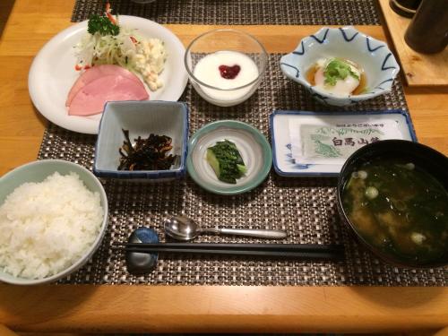 a table topped with bowls and plates of food at 旅館FURUYA in Hakuba