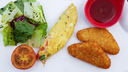 a plate of food with vegetables and a bowl of sauce at The Twizt - Lifestyle Hostel & Hotel in Siem Reap