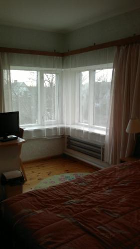 a bedroom with two windows and a bed and a desk at Transvaali 28 B&B in Kuressaare