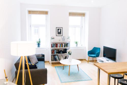 sala de estar con sofá y mesa en Bright, central and stylish city apartment en Viena