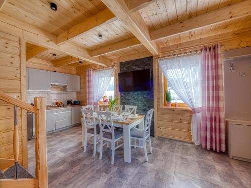 a kitchen and dining room with a table and chairs at Domki Szarotki in Groń