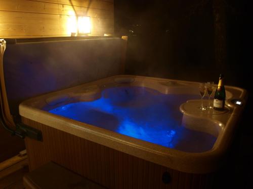 a hot tub with a bottle of wine and two glasses at Beechwood Hotel in North Walsham
