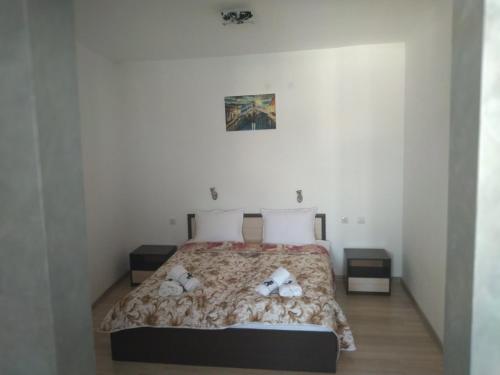 ein Schlafzimmer mit einem Bett mit zwei Teddybären darauf in der Unterkunft Семеен Хотел Дани in Assenowgrad