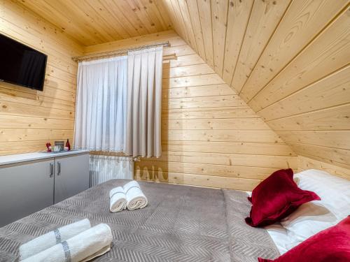 a bedroom with a bed in a wooden room at Domki Szarotki in Groń