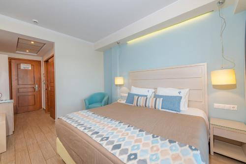 a bedroom with a large bed with blue walls at Odysseus Hotel in Paleokastritsa