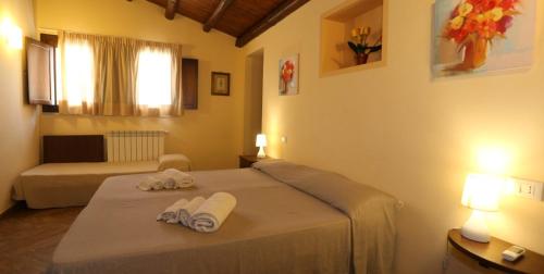 a bedroom with a bed with towels on it at Il Parco Di Nonna Betty in Lascari