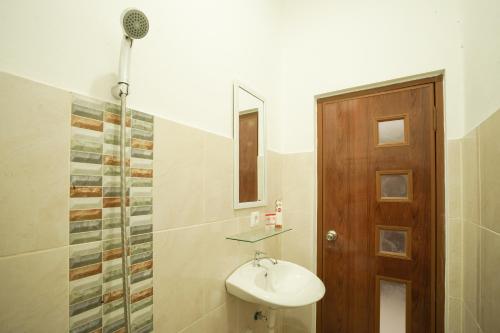 y baño con lavabo y ducha. en Super OYO 2183 Cibeureum Residence, en Bandung