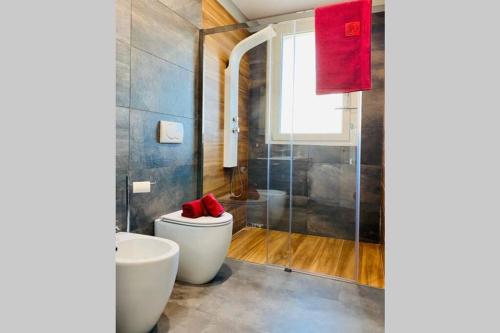 a bathroom with a toilet and a shower with red towels at Appartamento Moderno Soverato in Soverato Marina