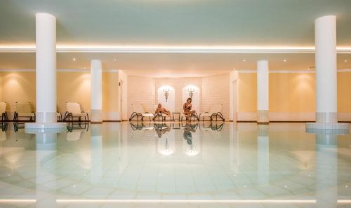 a lobby with two people sitting at a table at Hotel Condor in San Vigilio Di Marebbe