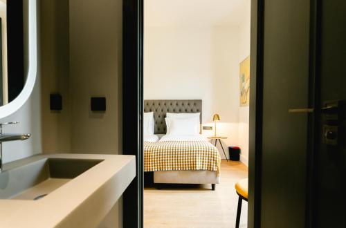 a bathroom with a bed and a sink in a room at Joya del Casco Boutique Hotel by Shiadu in Seville