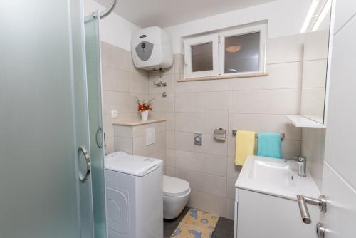 a small bathroom with a toilet and a sink at Apartments Mate in Bol
