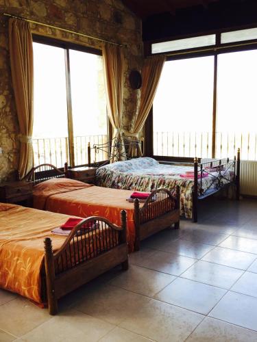 a room with three beds and windows in a building at Studio with view in Polis area in Paphos