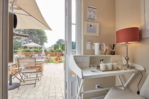 a kitchen with a table and chairs and a patio at Les Villas d'Arromanches, Teritoria in Arromanches-les-Bains