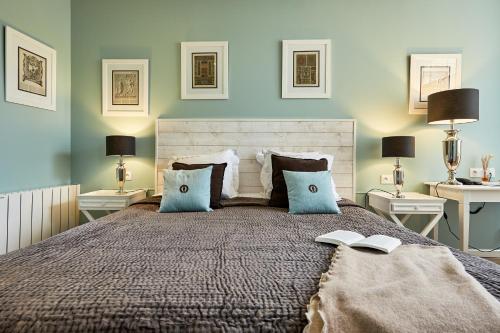 a bedroom with a bed with two tables and two lamps at Les Villas d'Arromanches, Teritoria in Arromanches-les-Bains