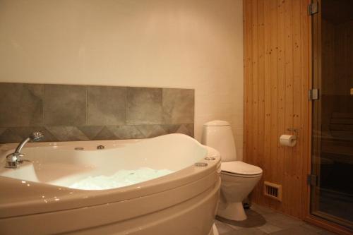 a bathroom with a tub and a toilet at Havrevang, Luksus ferielejligheder in Lønstrup