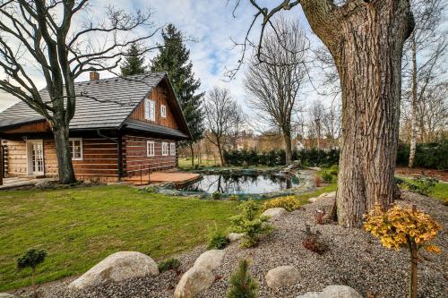 una casa de madera con un estanque en el patio en Roubenka Štěpánka, en Svratka
