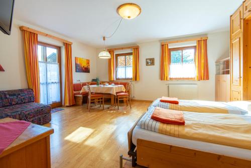 バート・ホーフガシュタインにあるHaus Noricumのベッド2台付きの部屋、テーブル付きのダイニングルームが備わります。