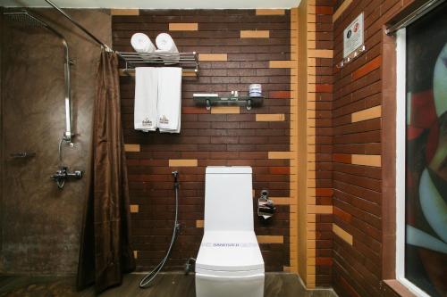 a bathroom with a toilet and towels on a wall at Sasha Transit Hotel in Katunayake
