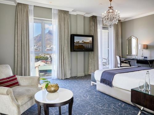 a hotel room with a bed and a living room at Queen Victoria Hotel by NEWMARK in Cape Town
