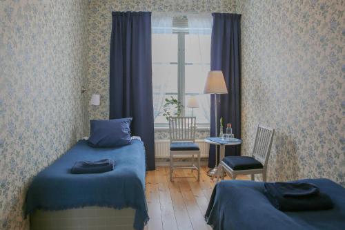 a bedroom with two twin beds and a window at Polhem Bed & Breakfast in Falun