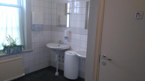 a white bathroom with a sink and a mirror at Polhem Bed & Breakfast in Falun