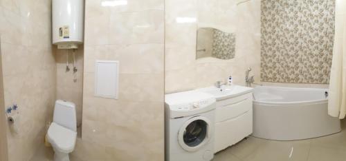 チェルカースィにあるApartament near Dnieperのトイレの隣に洗濯機が付いたバスルームがあります。