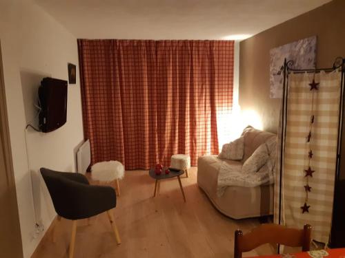 ein Wohnzimmer mit einem Sofa und einem Tisch in der Unterkunft RESIDENCE UBAYE T 2 in Barcelonnette